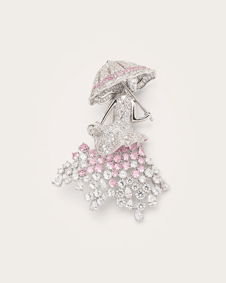 Noora Crystal Parasol Lady Brooch in silver tone with pink and clear crystals on a warm pale background