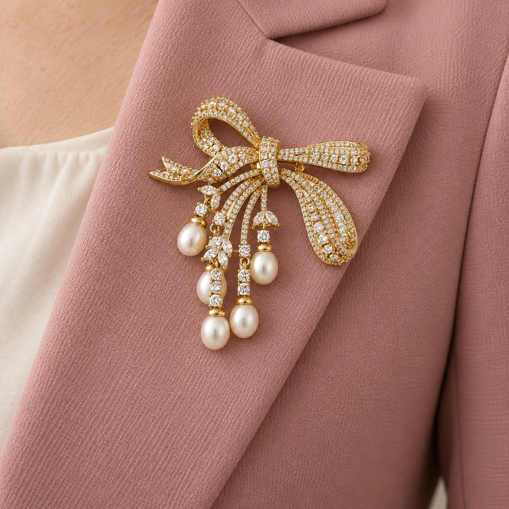 Lova pearl bow brooch on a dusty rose jacket lapel