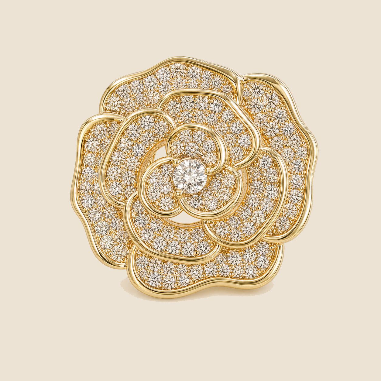 Valo Crystal Camellia Brooch in gold tone with clear pavé crystals on a warm beige background
