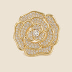 Valo Crystal Camellia Brooch in gold tone with clear pavé crystals on a warm beige background