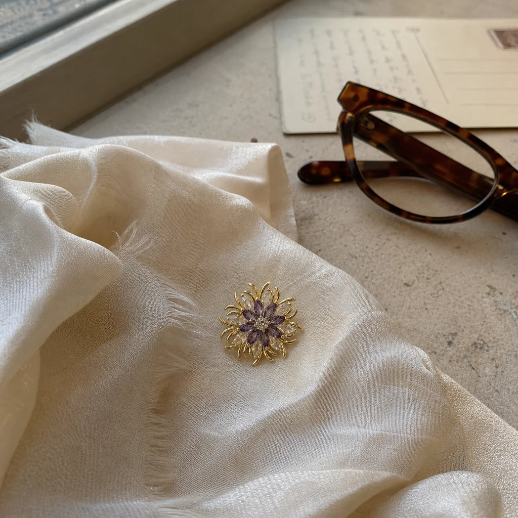 Purple and Gold Meri Magnetic Bloom Brooch in a silk scarf travel still life