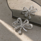 Back and pin view of Sylvi Crystal Ribbon Brooch beside a mirror