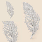 Four detail views of the Lumi Crystal Feather Brooch showing its crystal tip, open feather branches, curved vane and tapered stem