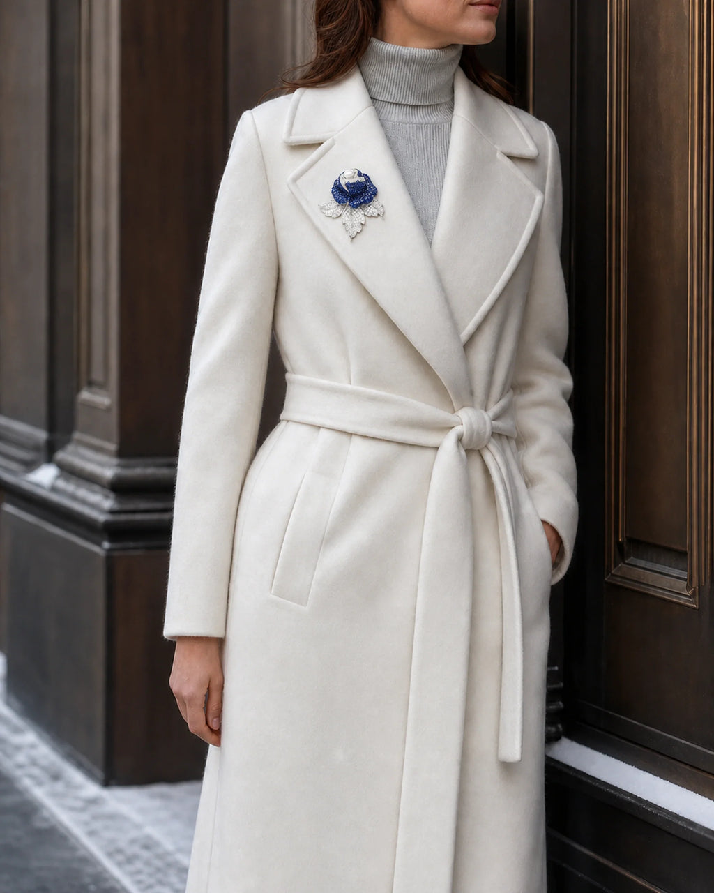 Wide view of Aava at true scale on a winter-white coat lapel