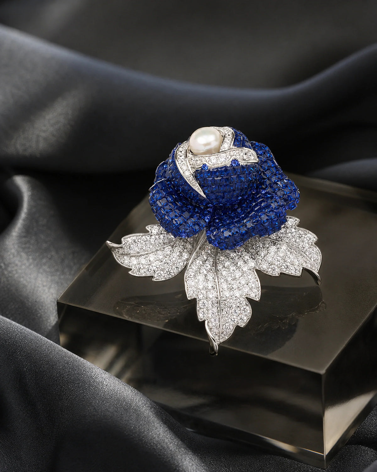 Aava sapphire rose brooch resting on smoked glass in an original TUUGLOW still life