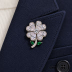 The complete silver-tone clover sits inside one broad navy wool folded lapel.