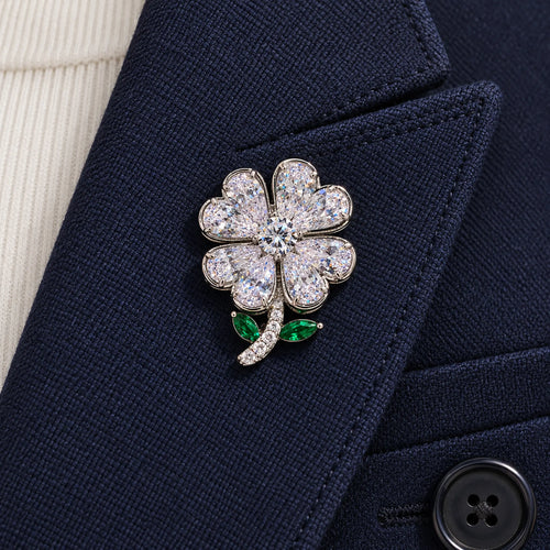The complete silver-tone clover sits inside one broad navy wool folded lapel.