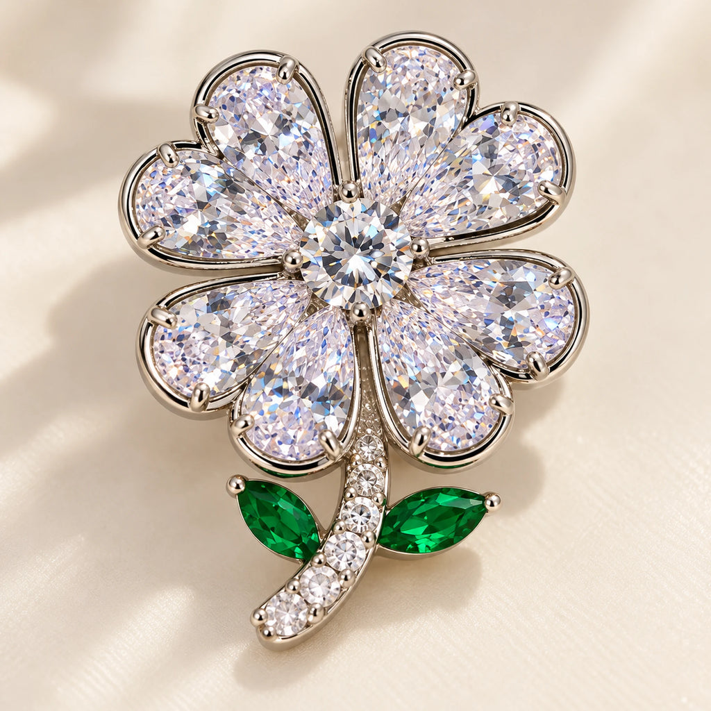 Paired clear pear-shaped zircon fill the heart-shaped leaves around a round centre stone.