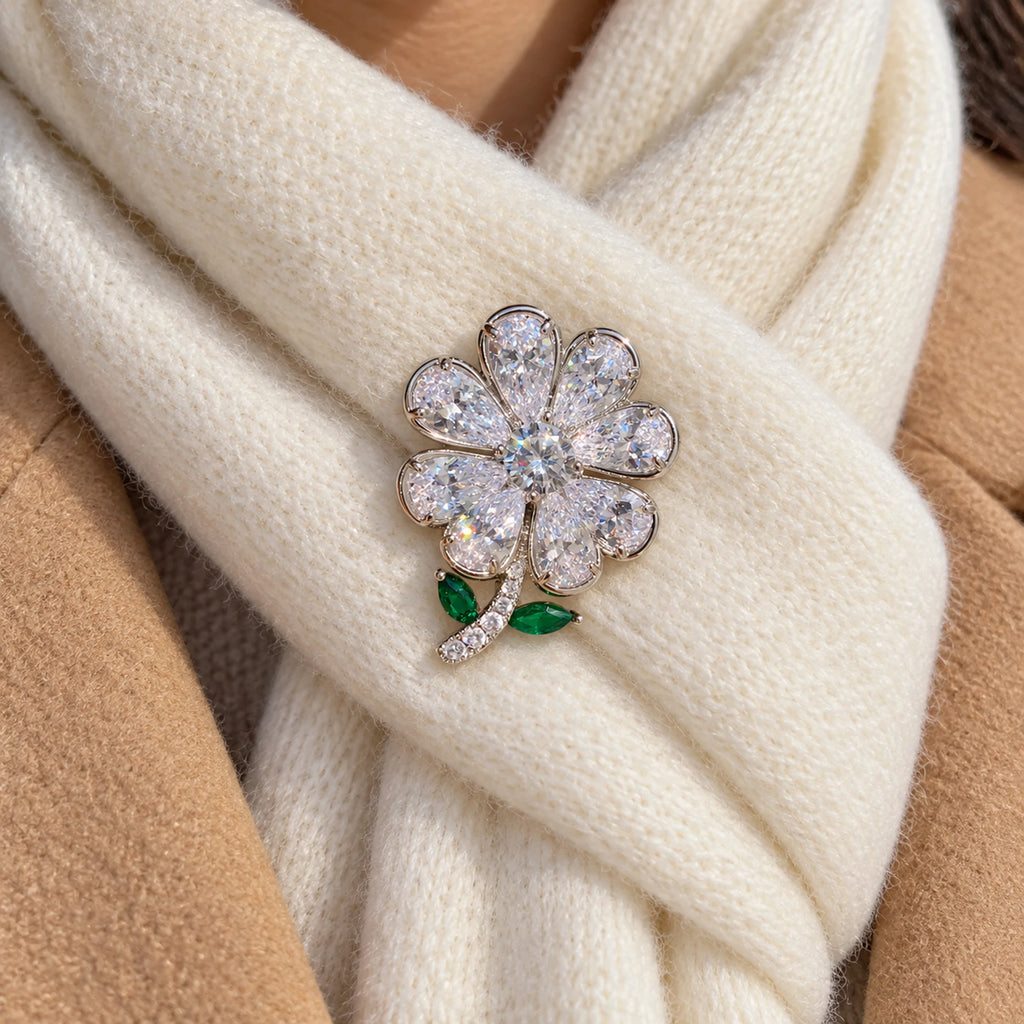 A doubled ivory wool scarf supports the clover, curved stem and green leaves.