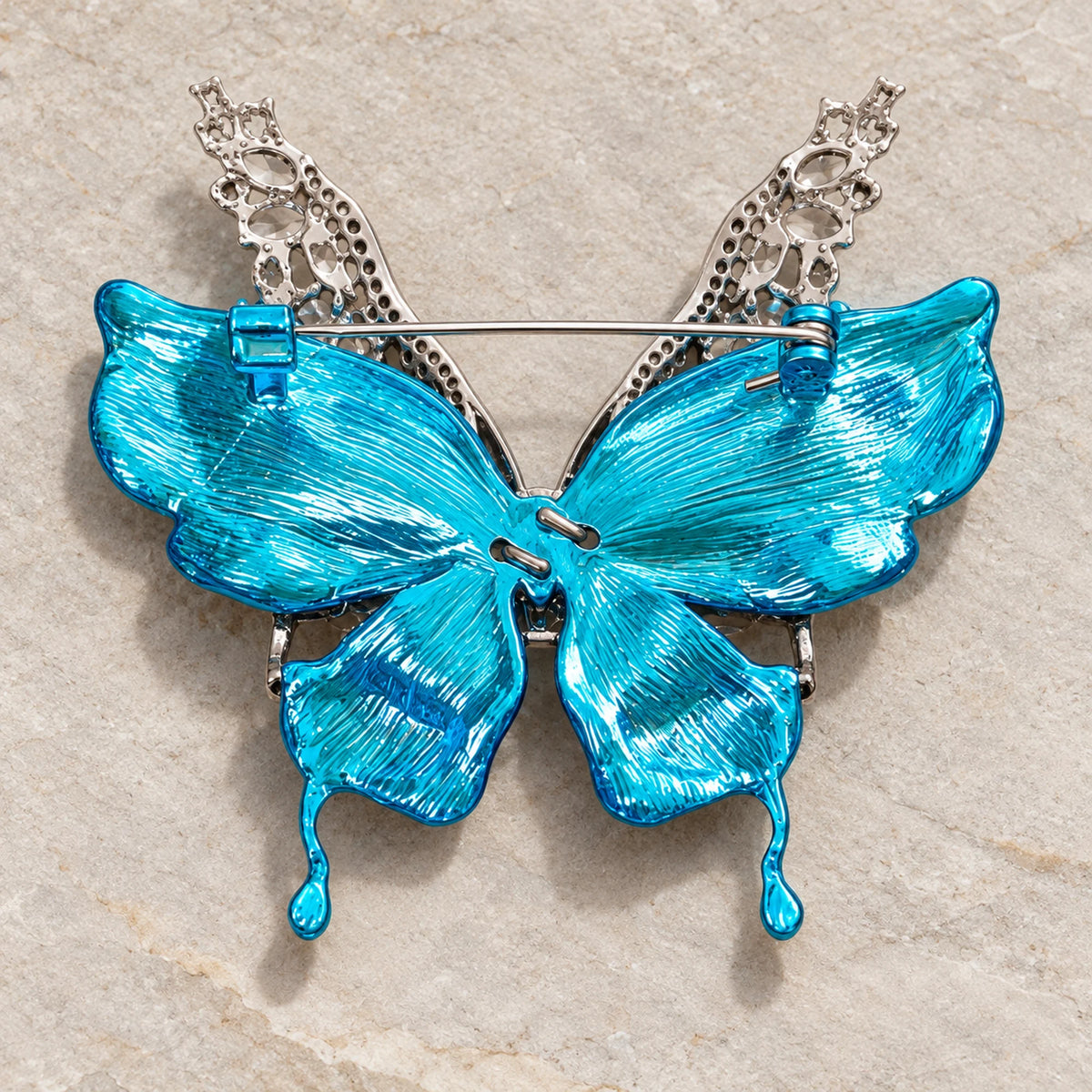 Rear view of Airi brooch showing textured turquoise wing backs, horizontal pin and safety catch.