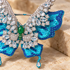 Close detail of the green oval centre, clear stone settings and sculpted turquoise wing.