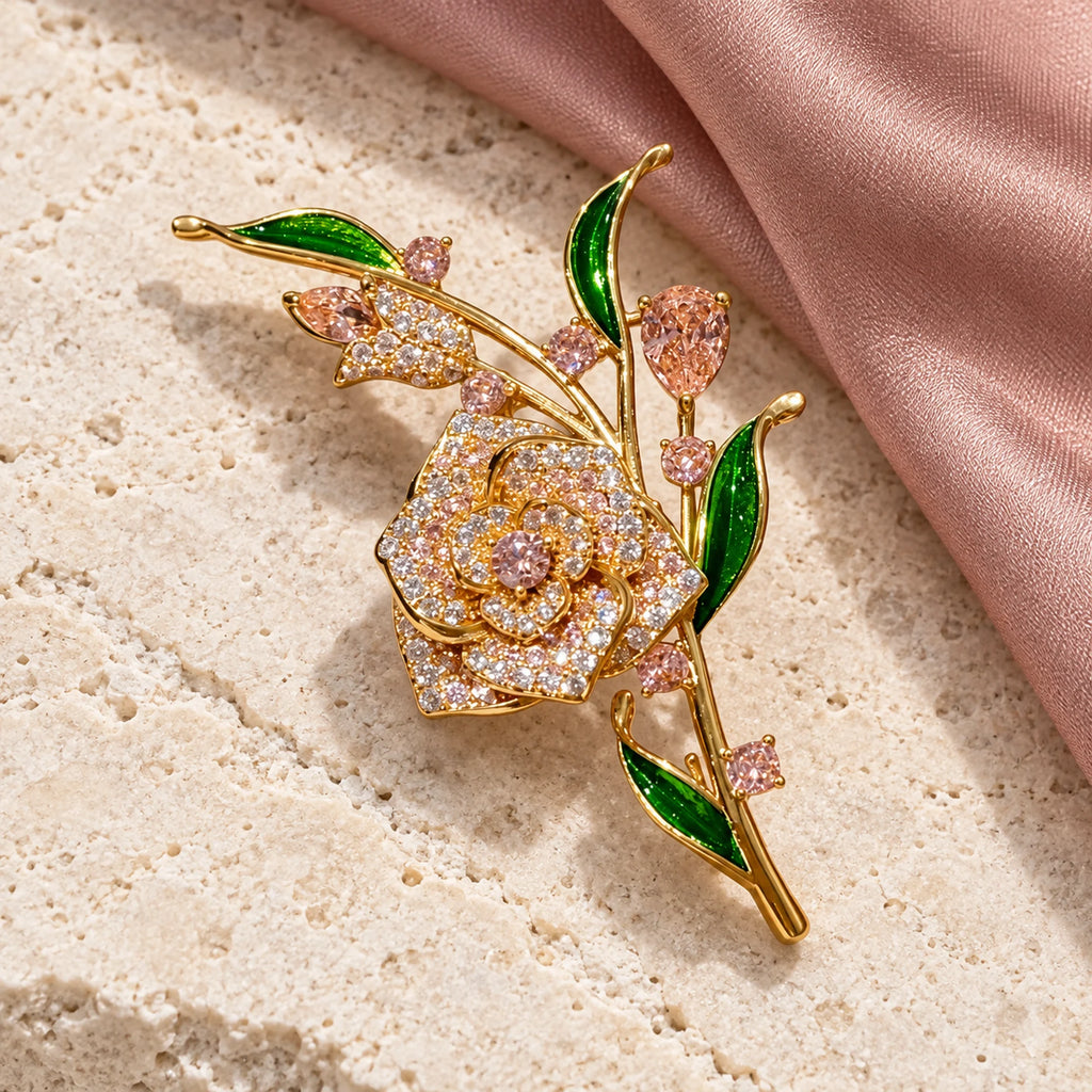 Complete Alva Pink Zircon Rose Brooch resting on pale stone beside softly folded silk.