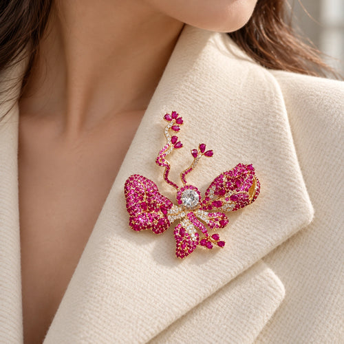 The rose-pink butterfly sits fully inside an ivory folded lapel.
