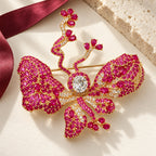 Complete Anni Rose Pink Butterfly Brooch resting on ivory paper beside silk and pale limestone.