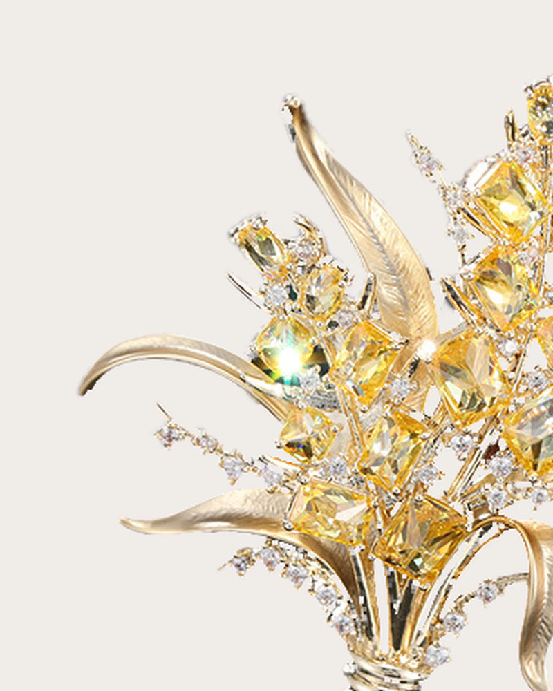 Detail of Aurea curved polished leaves, yellow zircon accents and slender gold-tone stems