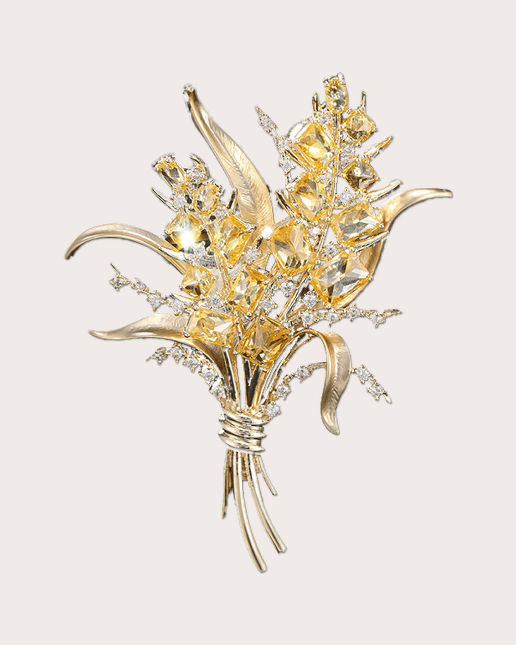 Aurea gold-tone wheat sheaf brooch with yellow zircon accents on a warm neutral background