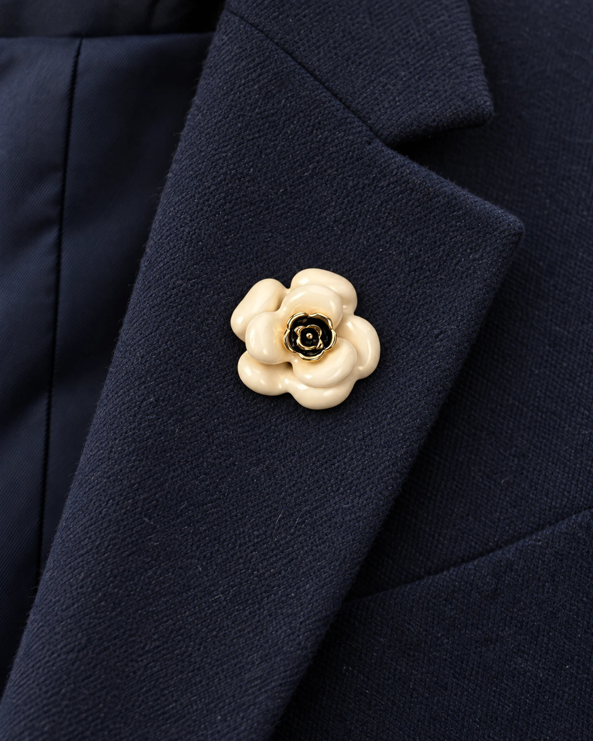 Auri Ivory Camellia Magnetic Brooch, Gold & Ivory worn on a navy jacket lapel, close view