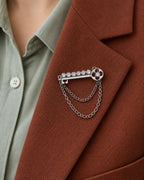 Avain Key Double Chain Brooch in silver-tone finish — close wearing view on a jacket lapel