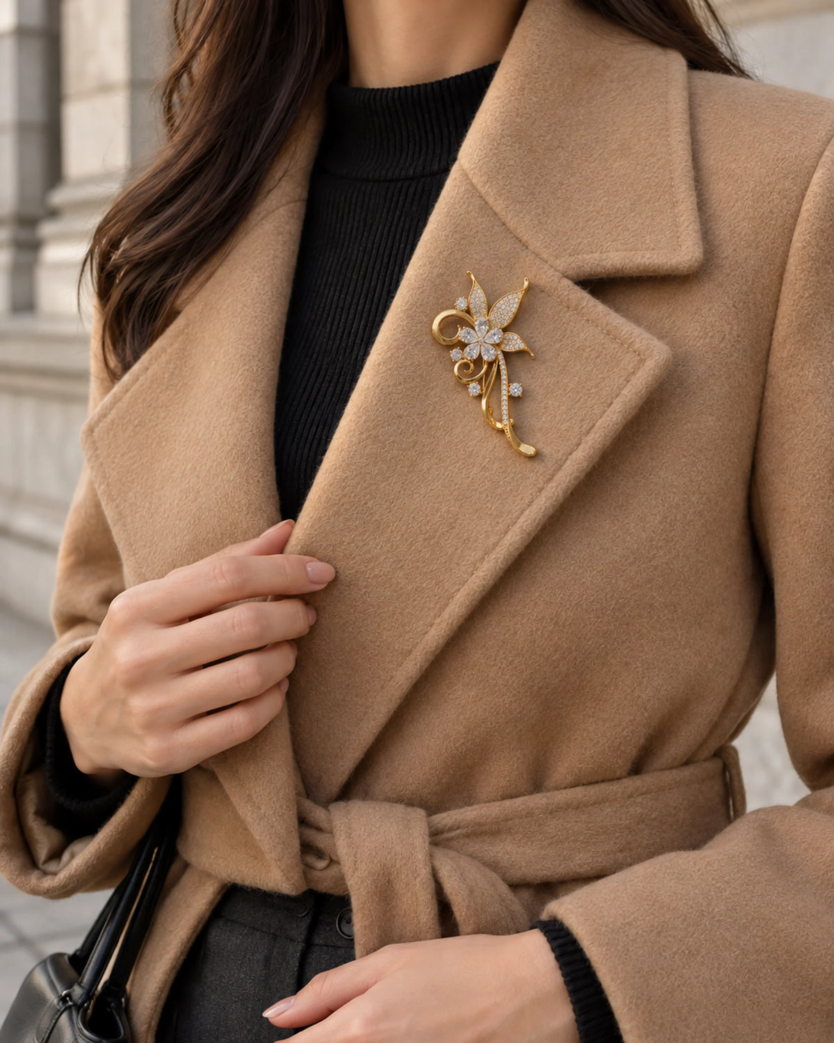 Avelia worn on a camel coat with a black knit, wider styling view