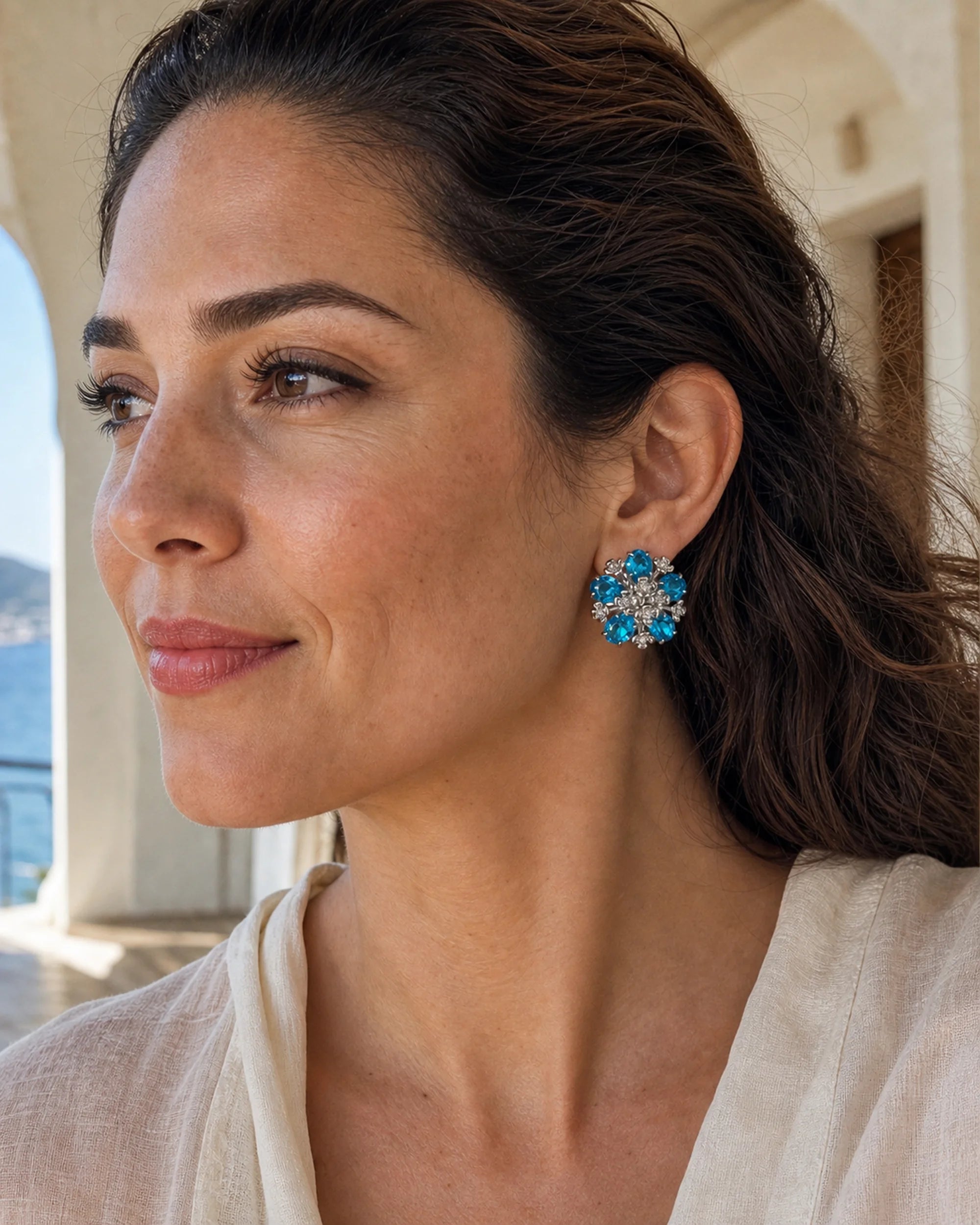 Close on-ear view of the Azura blue glass floral earrings at their natural 2.8 cm scale.
