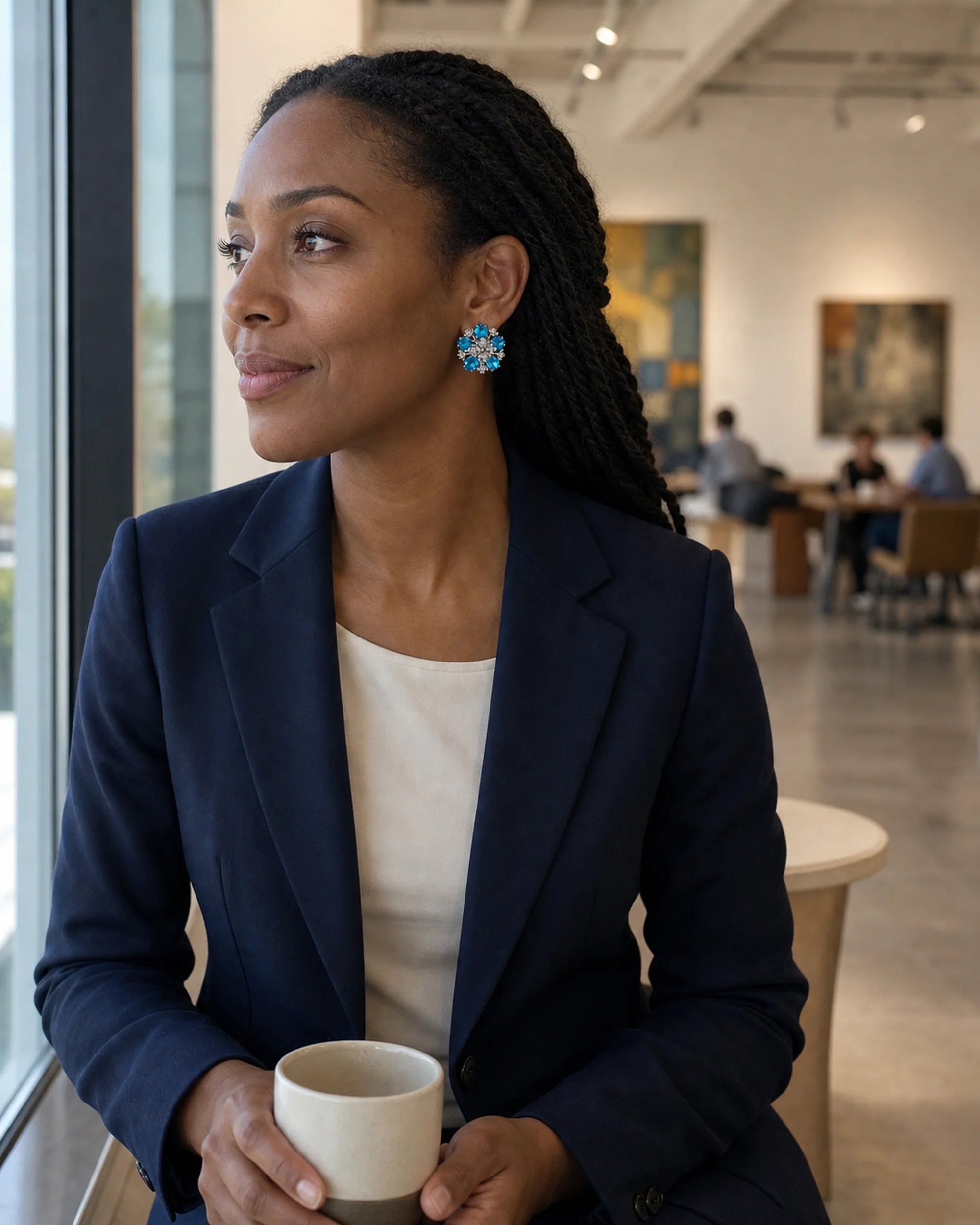 Azura blue glass floral earrings worn with a clean neckline in a wider natural-light portrait.