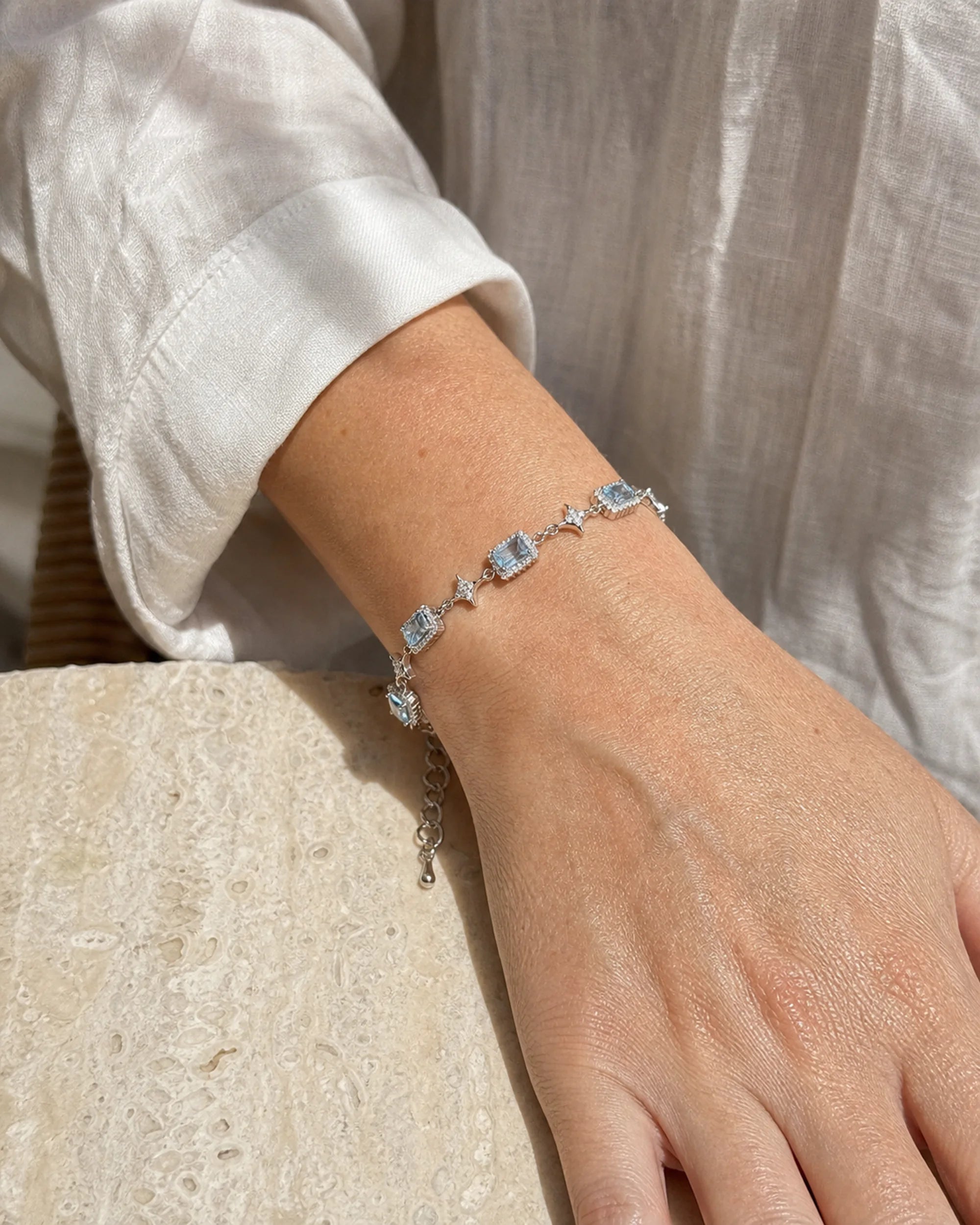 Close wrist view of the Celeste Blue Zircon Star Bracelet showing five blue zircon centers and four-point star links.