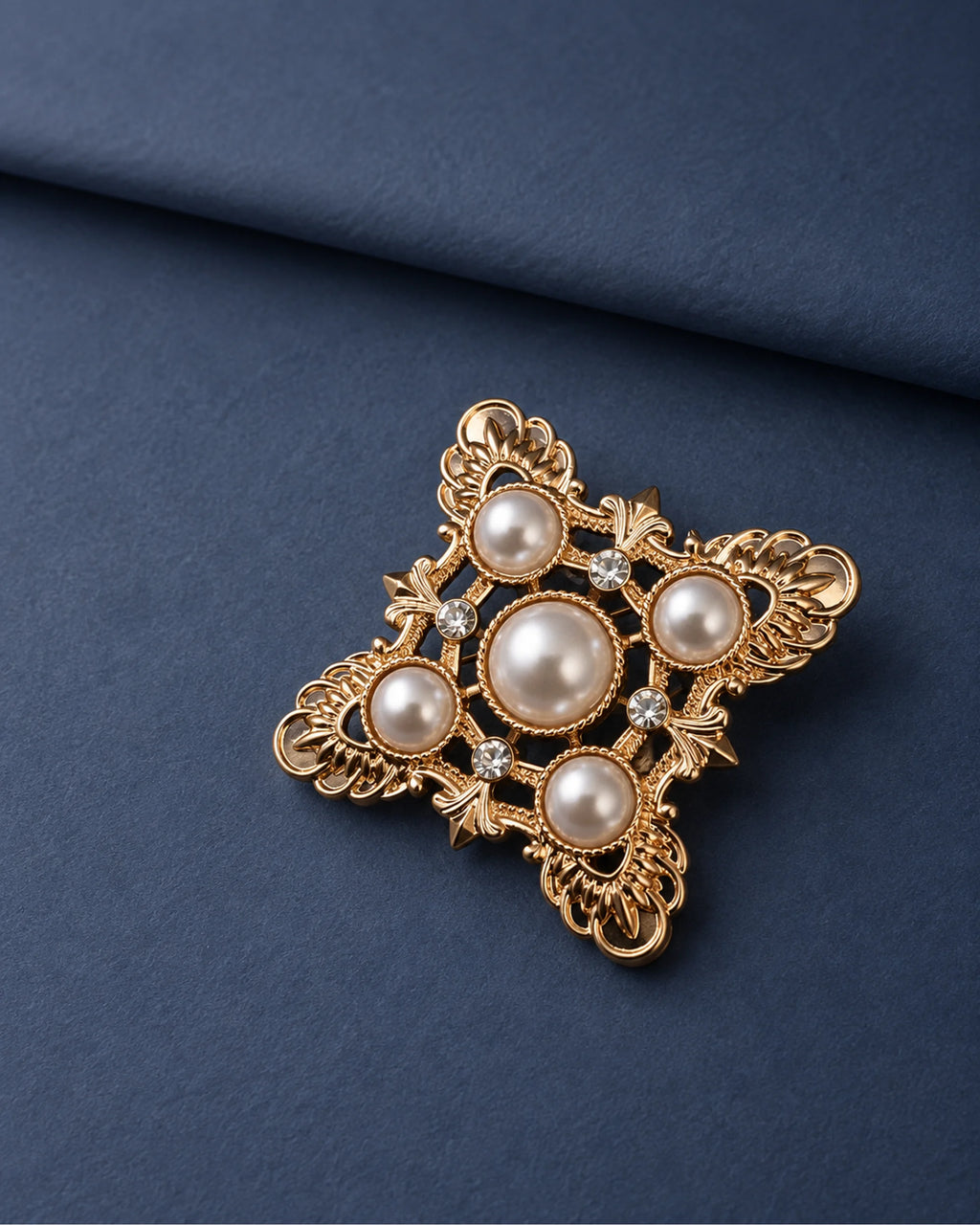 Dagny Pearl-Style Openwork Cross Brooch — front display on folded slate-blue paper