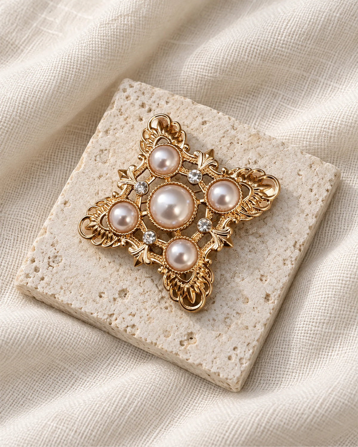 Dagny Pearl-Style Openwork Cross Brooch — front view on a stone tile and ivory linen