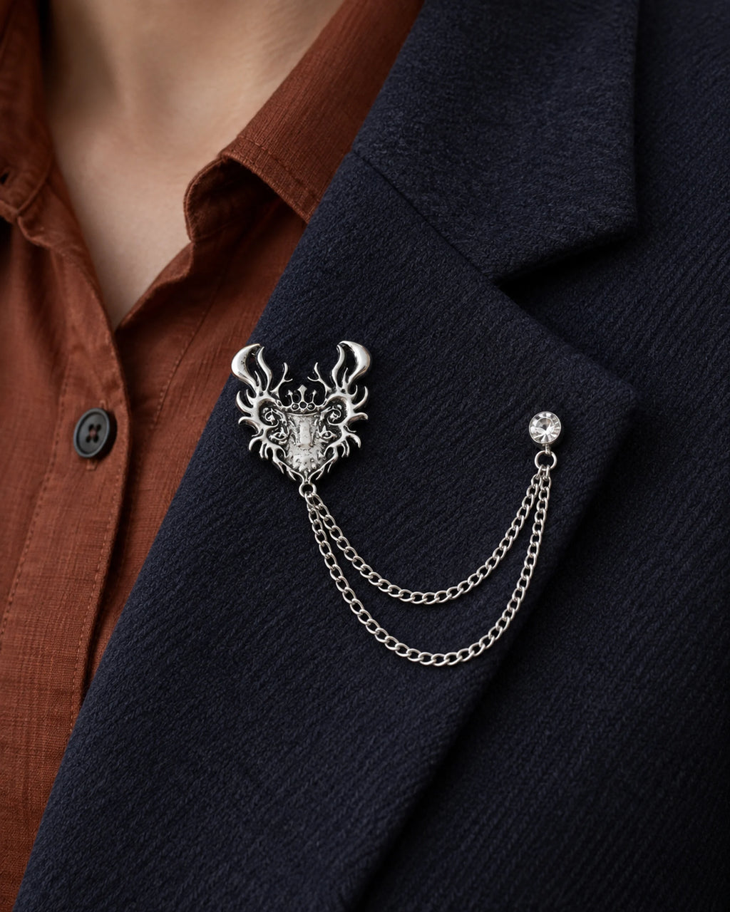 Draka Horned Crest Lapel Chain Brooch in silver-tone finish; close wearing view on a structured lapel