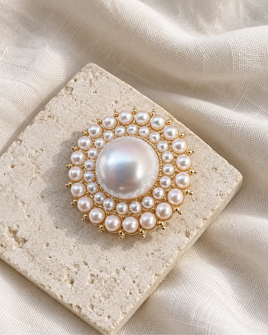 Elin Round Pearl-Style Cluster Brooch — front view on a stone tile and ivory linen