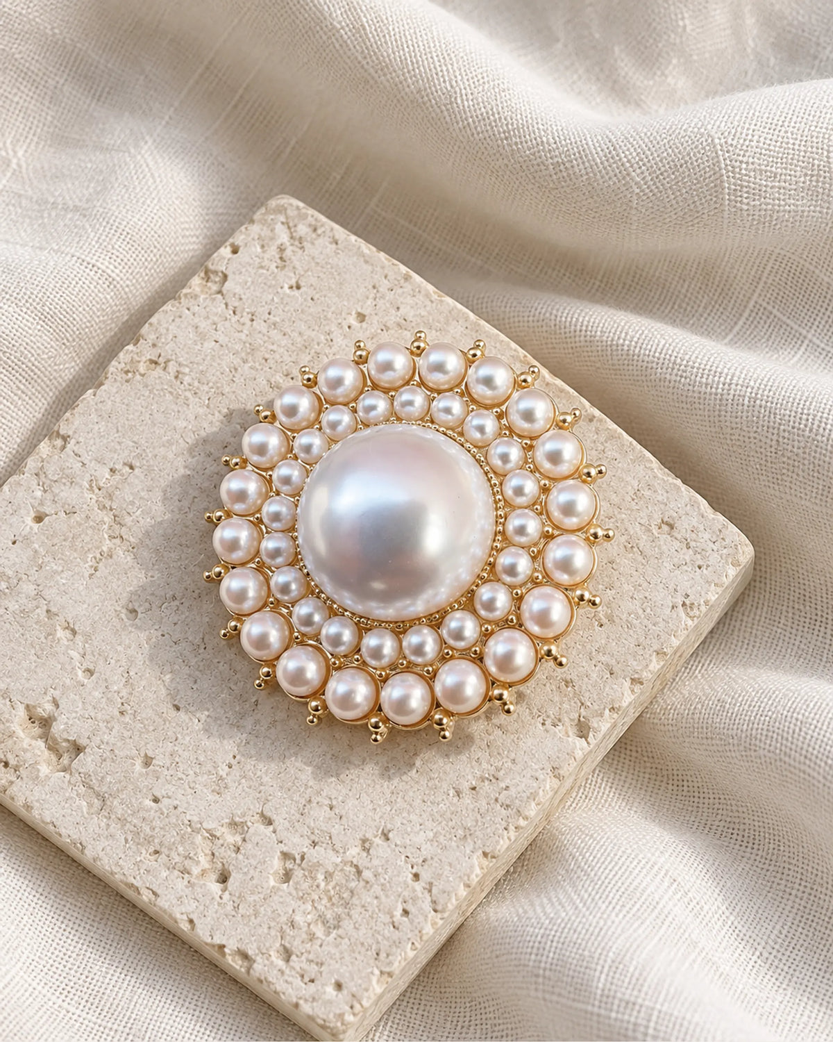 Elin Round Pearl-Style Cluster Brooch — front view on a stone tile and ivory linen