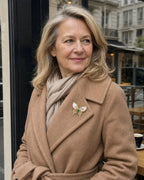 Elina green shell butterfly brooch worn at its natural 4.2 cm width on a camel wool coat beside a café window.