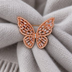 Doubled pale-gray wool scarf folds support the Rose Gold & Pink butterfly.