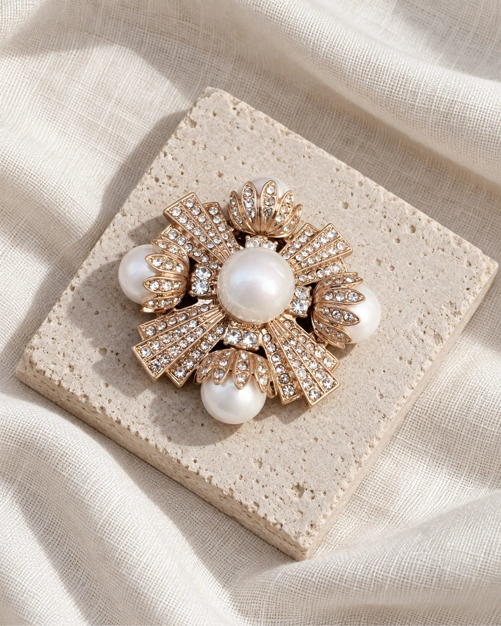 Estrid Pearl-Style Star Cross Brooch — front view on a stone tile and ivory linen