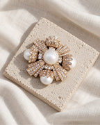 Estrid Pearl-Style Star Cross Brooch — front view on a stone tile and ivory linen