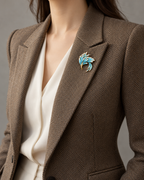 Fenix Sweeping Phoenix Brooch — Blue & Gold worn on a brown herringbone lapel