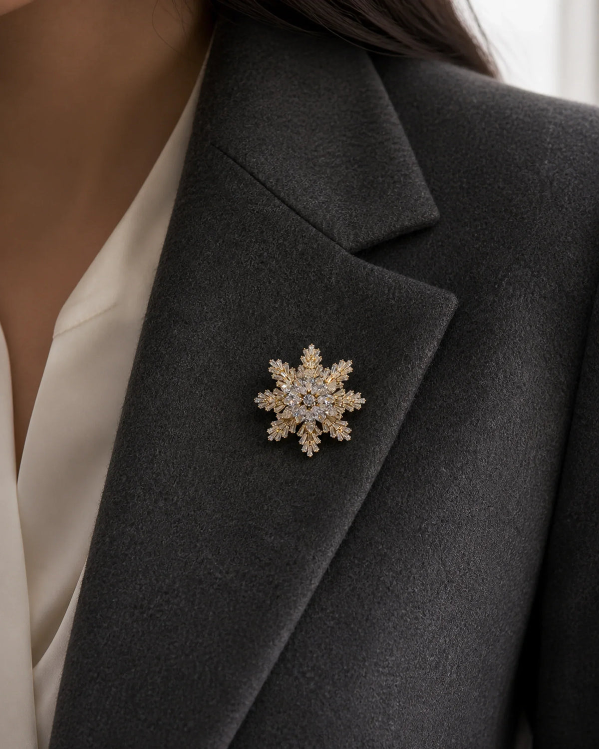 Close view of the 2.2 centimetre Halla Snowflake Brooch pinned fully to the folded lapel of a charcoal blazer