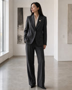 Full styling view showing the true small 2.2 centimetre scale of the Halla Snowflake Brooch on a charcoal suit lapel