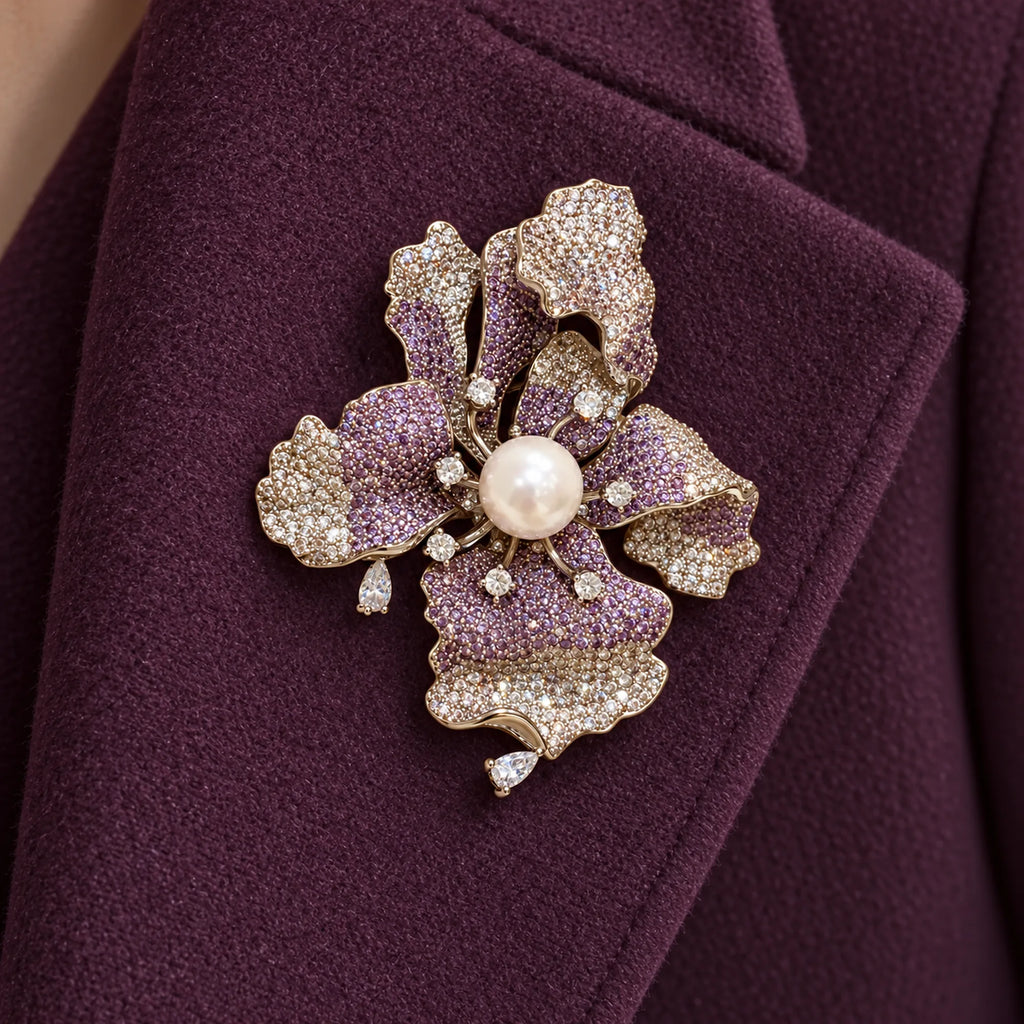 Iiris iris brooch pinned fully within a broad folded plum wool coat lapel.