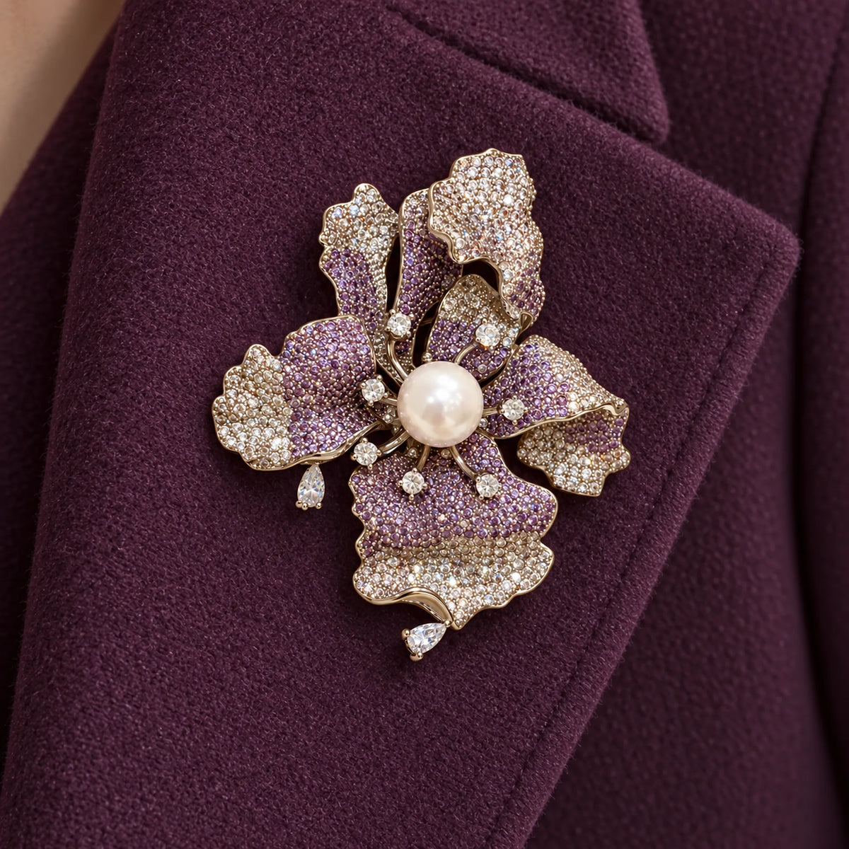Iiris iris brooch pinned fully within a broad folded plum wool coat lapel.