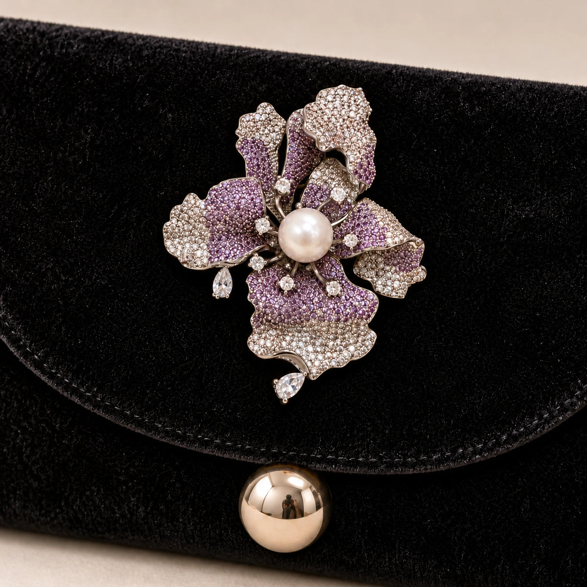 Iiris iris brooch secured to the reinforced velvet flap of a black evening clutch.