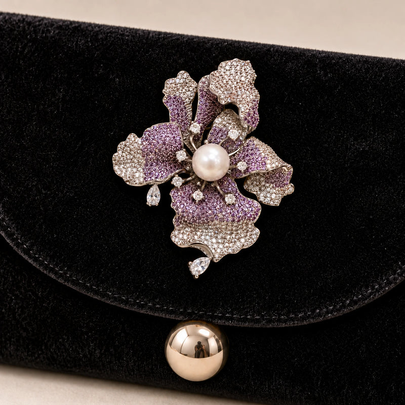 Iiris iris brooch secured to the reinforced velvet flap of a black evening clutch.
