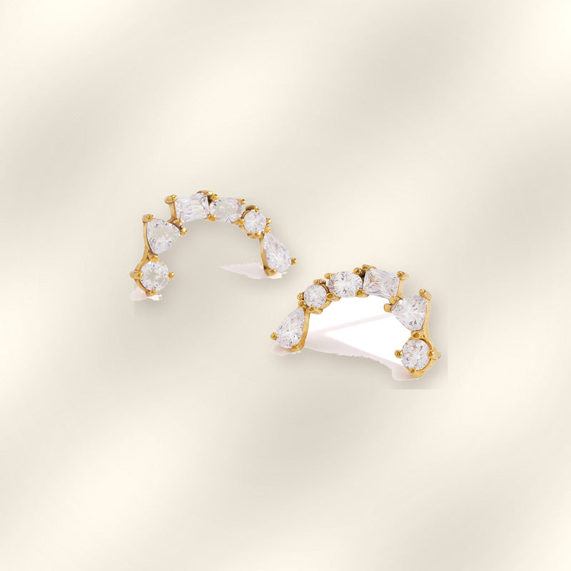 Pair of Ilo Smile Pave Stud Earrings on soft satin background