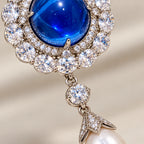 Macro of the blue cabochon, clear zircon halo, articulated link and pearl cap on Inari.