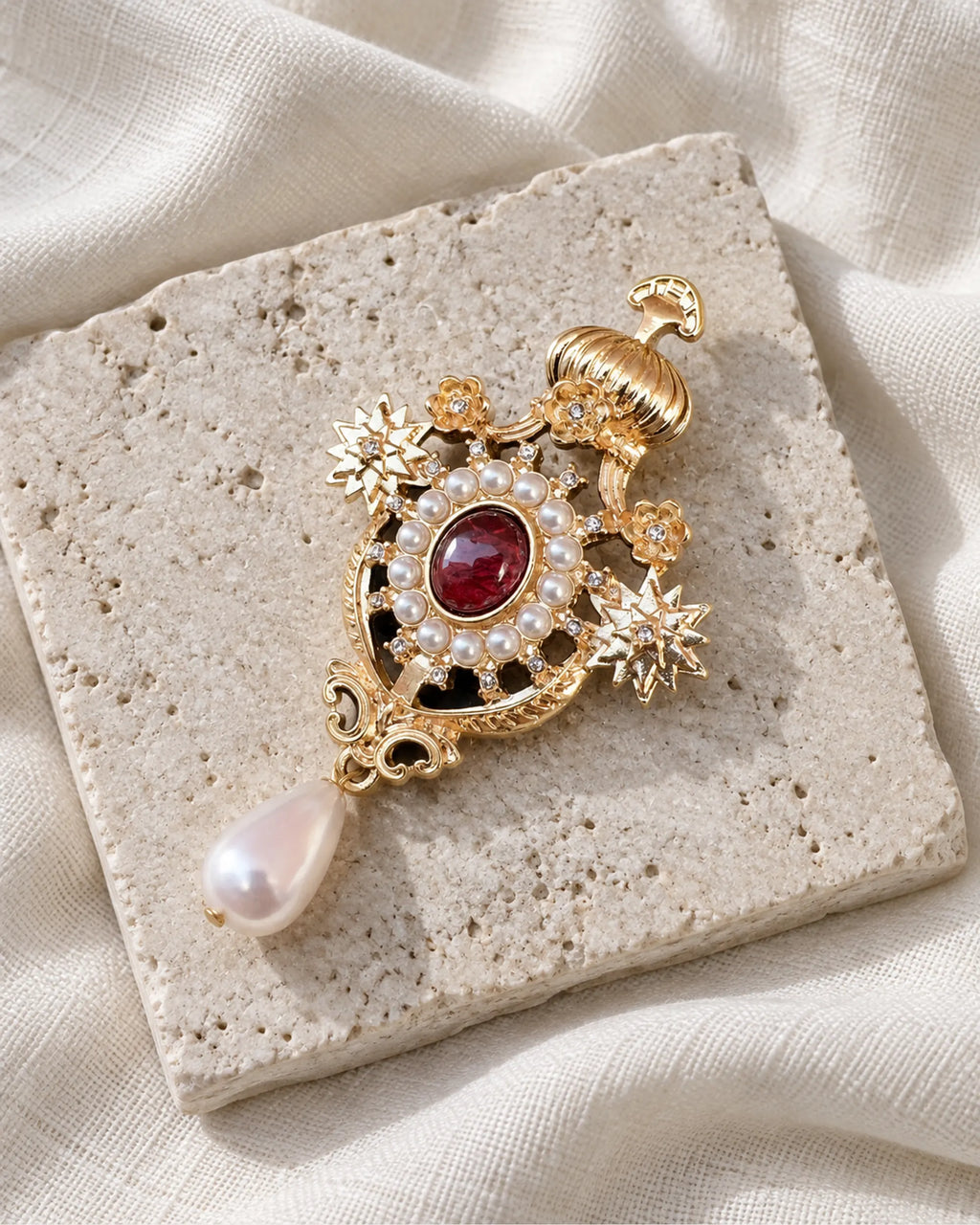 Ingrid Red Crown Drop Brooch — front view on a stone tile and ivory linen