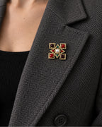 Ivar Red and Green Cross Brooch — model wearing the brooch on a jacket lapel, close view