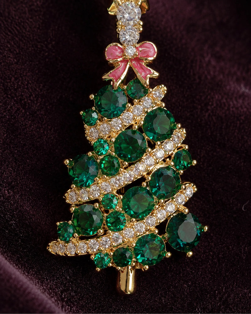 Close view of green faceted stones, clear-stone garlands and the red bow.