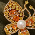 Champagne zircon and a pearl-look centre rise above the gold-plated openwork.