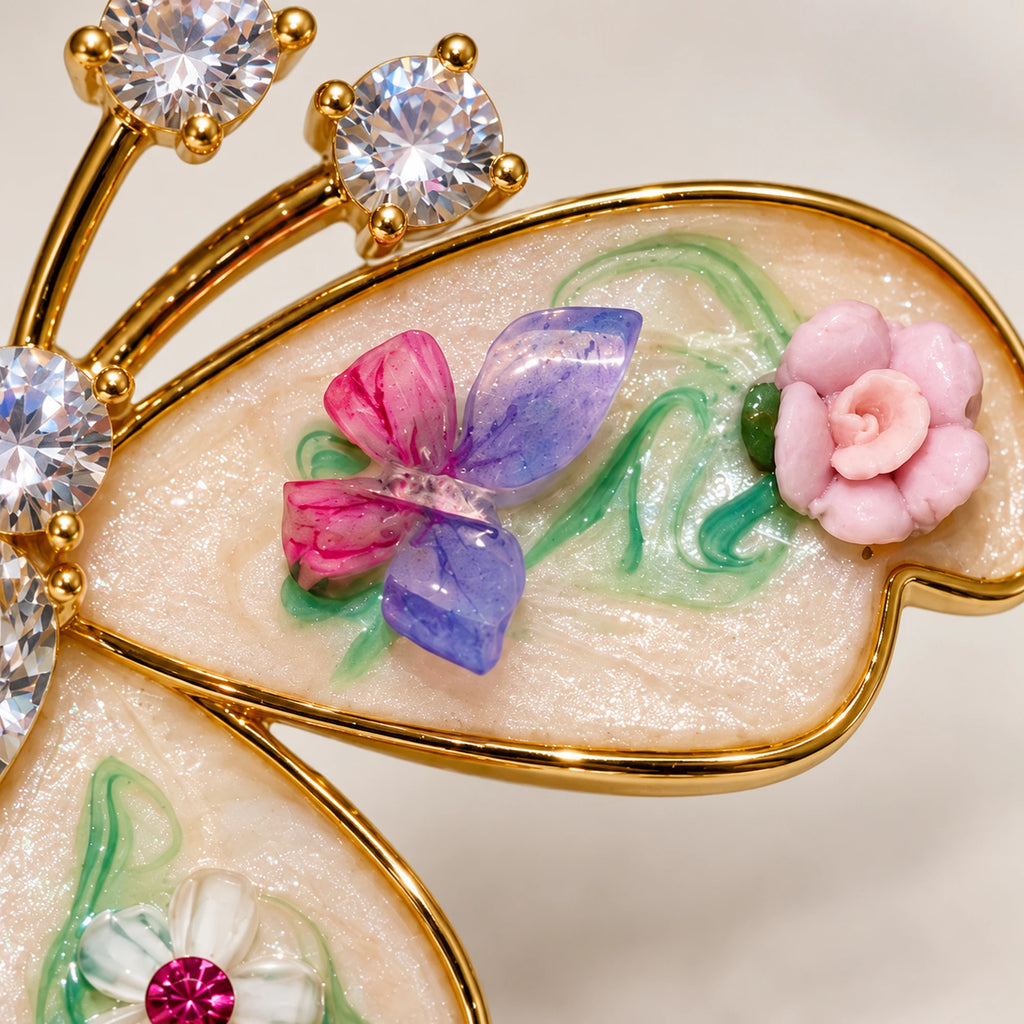 Macro of Kielo’s pearlescent upper wing, pastel floral relief, clear zircon head and gold-tone boundary.