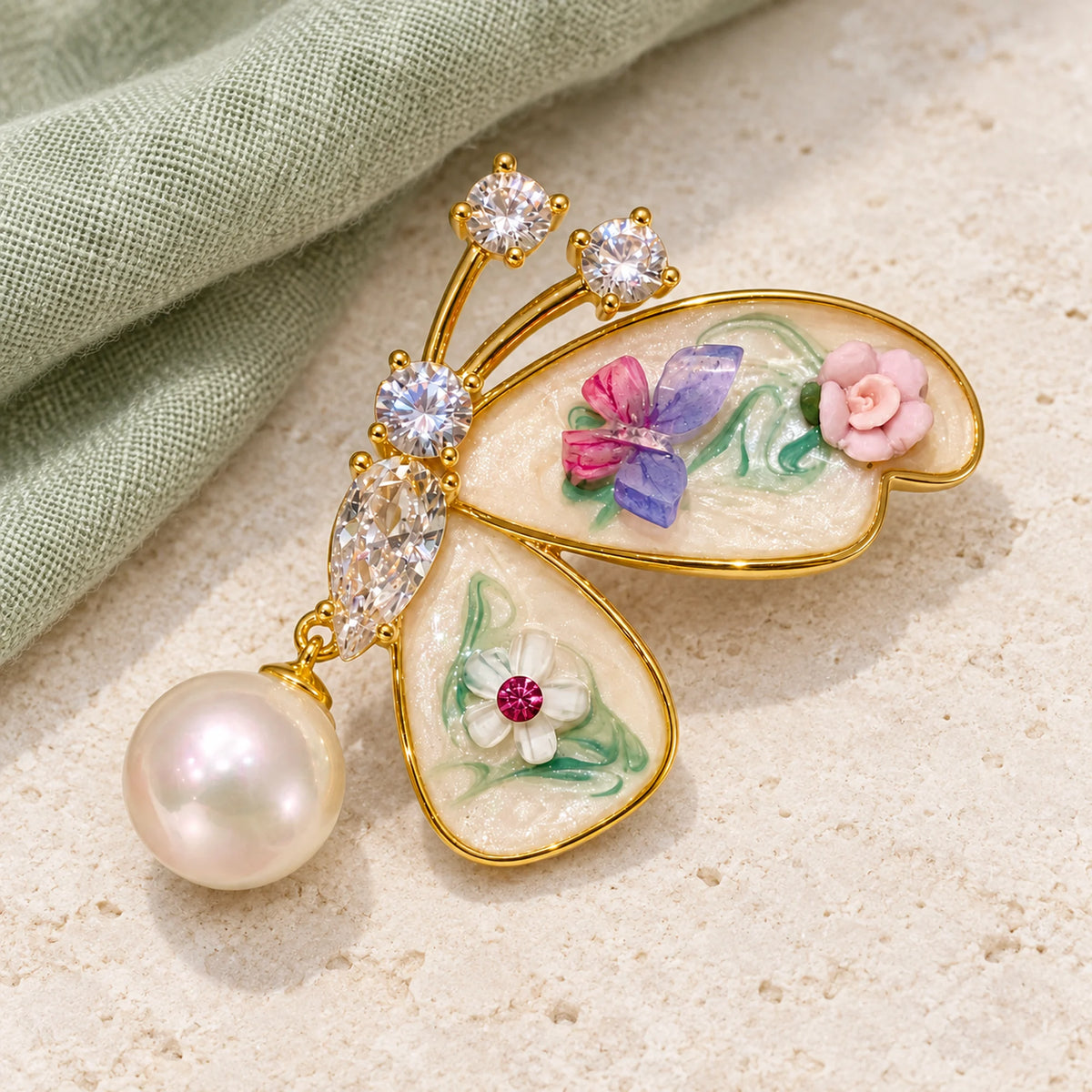 Complete Kielo butterfly brooch on pale limestone with a fold of sage linen.